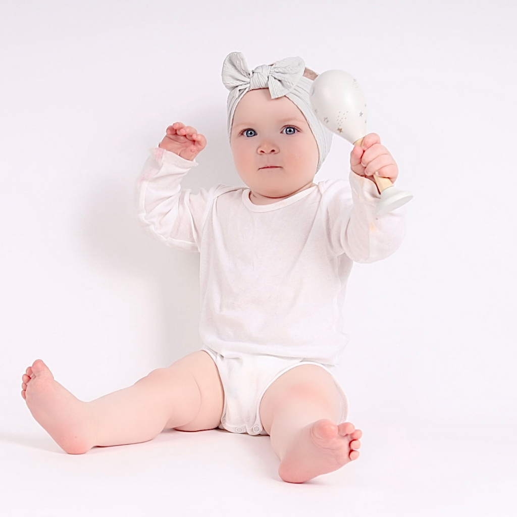 Baby play time with a wooden maraca out of the 3-6 month subscription box.