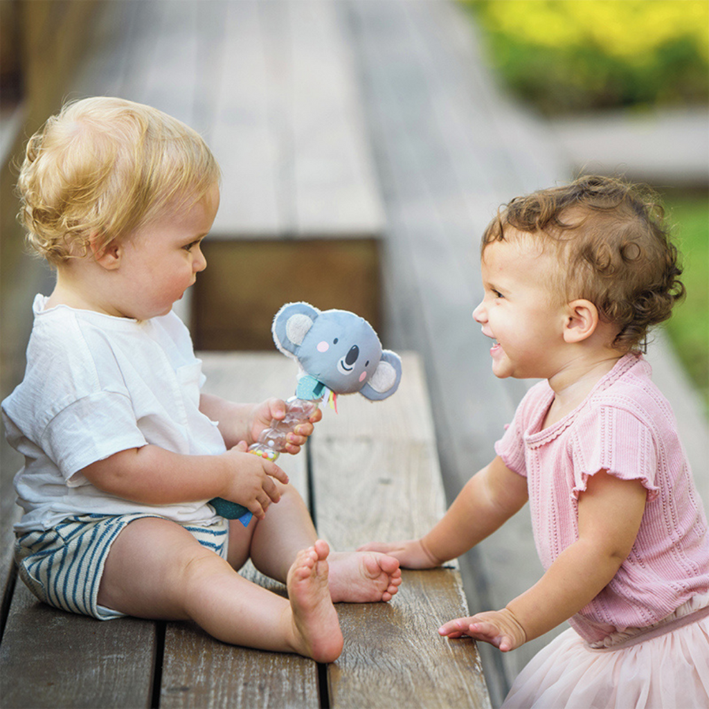 Two babues playing with the taf toys koala rainstick baby rattle