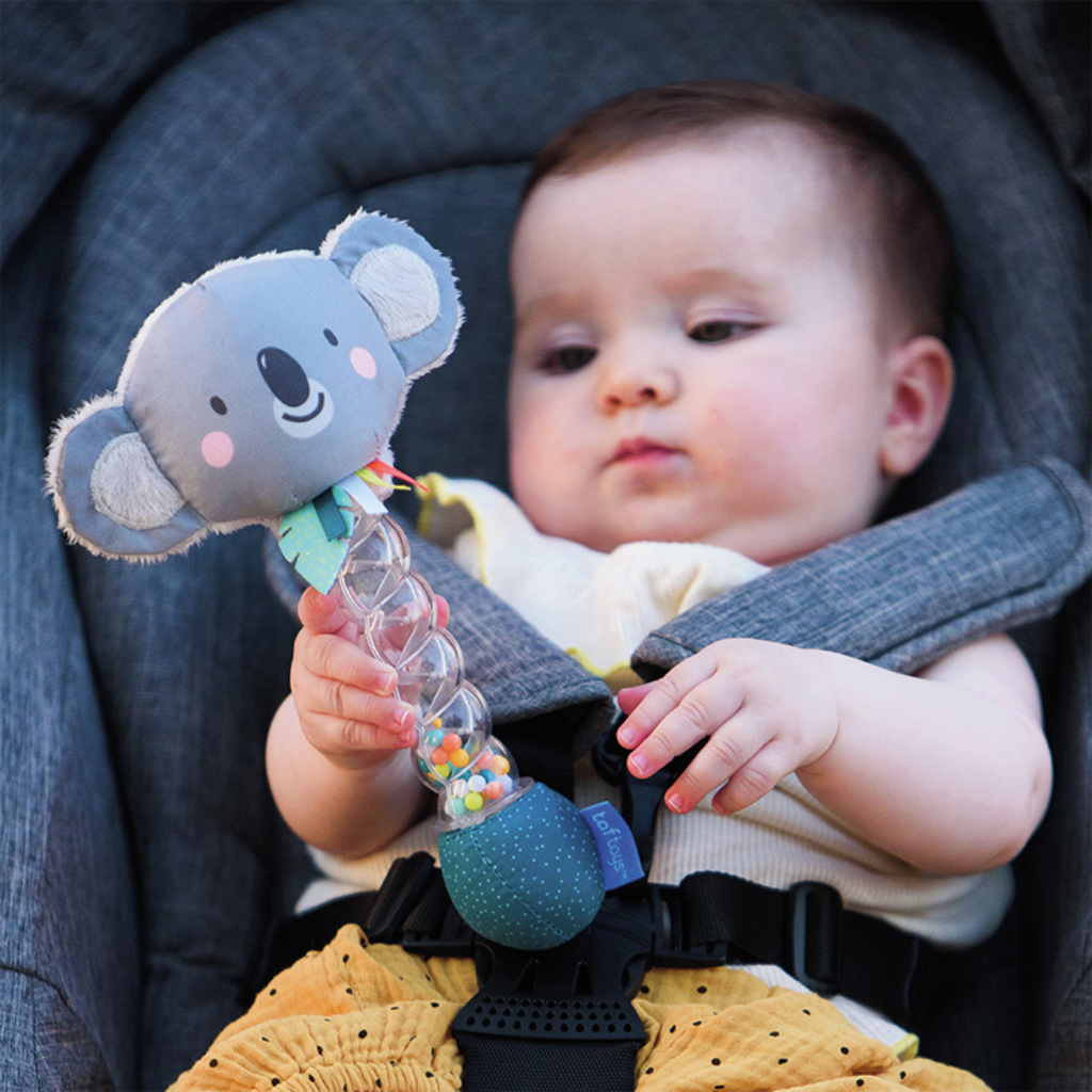 A baby holding taf toys koala rainstick baby rattle