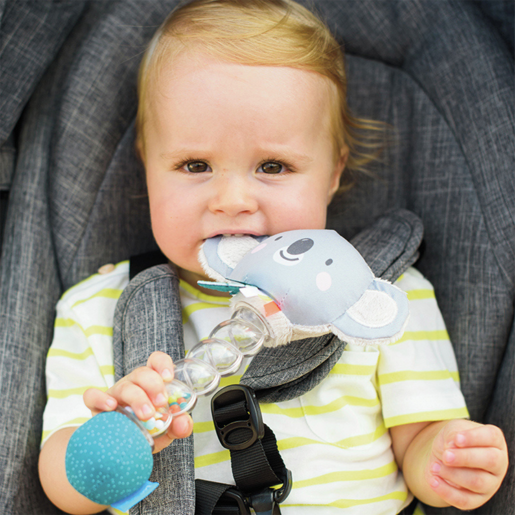 A baby chewing on the taf toys koala rainstick baby rattle